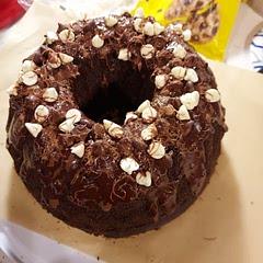 Covered with a chocolate glaze, then chocolate shavings from a candy bar and white chocolate chips. This cake is a winner every time!