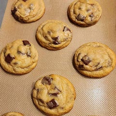 Mixed in chocolate chunks with chocolate chips.  Chilled 24 hrs.  Form into tall balls BEFORE chilling.   When fresh out of oven swirl around inside a biscuit cutter for perfectly round cookie.