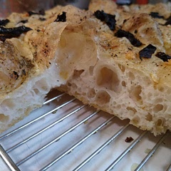 Beautifully bubbly!
Having little kids and being a lazy baker, I didn't follow the recipe meticulously but it still turned out delicious. I didn't knead the dough with hands but mixed it with a spatula in the bowl it was in a d it probably sat on my counter more than an hour before I put it in the fridge.
For toppings I used herb de provence, sun-dried tomatoes (stored in oil) and freshly minced garlic. The tomatoes got a bit toasty and slightly bitter after 22 min baking at 430F so I would try fresh tomatoes next time.