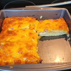 I made some adjustments and used what I had on hand. I mixed ham and onions in with the egg mixture and poured over the hash browns. I shredded fresh cheddar cheese for the top. Baked for 35 minutes. It came out delicious! 