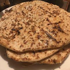 The trickiest part of this recipe was cooking them on the cast iron pan without excessive smoking.

I would recommend reapplying oil as needed and keeping the pan at medium high to avoid excess smoking. The pan is sufficiently hot at this temperature with this and the bread bubbles well.

I ended up having to add a bit more flour as the dough was very sticky, and I am glad I did. I kneaded for about 7-10 minutes and this made a supple, soft dough with delicious flavor. 

I highly recommend making garlic butter for the naan topping. It was fantastic!