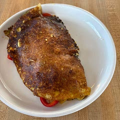 I did not have a nonstick pan so it’s important to spray oil in the pan before you add the batter. I heated the pan to medium high poured in the batter swirled it and covered with a lid. I let that cook for about two minutes. Then I turned the heat down to medium low for two minutes and took the lid off and let it dry out on top. I got a nice golden color. I sautéd the vegetables ahead of time, and added, half covering the omelette, and flipped over one side. I covered the pan again and turned down the pan to medium low and let it cook for five more minutes. It was a little challenging to get it out in one piece, because it is soft.

I also substituted Kala Namak black salt for herb salt.