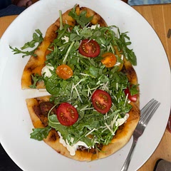 I am obviously a huge fan of arugula salad as a pizza topper. I topped this with a combo of pesto and pizza sauce, a couple slices of prosciutto and then baked for a few minutes. I pulled apart and added a ball of burrata, mixed seasoned arugula with lemon juice/olive oil to spread on top and sliced constellation tomatoes to place on top.
