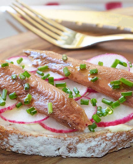 Tostadas con mantequilla, sardinas anchoadas y rabanitos