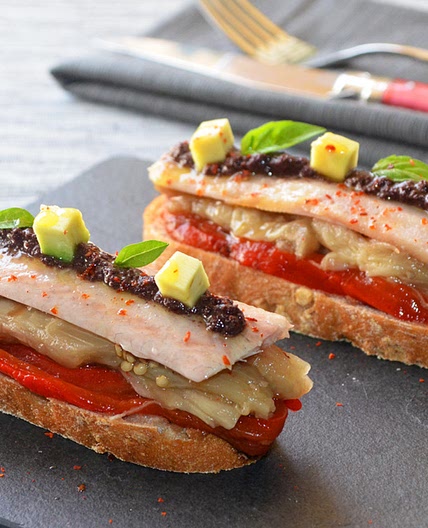 Tosta de escalibada con anguila ahumada y tapenade
