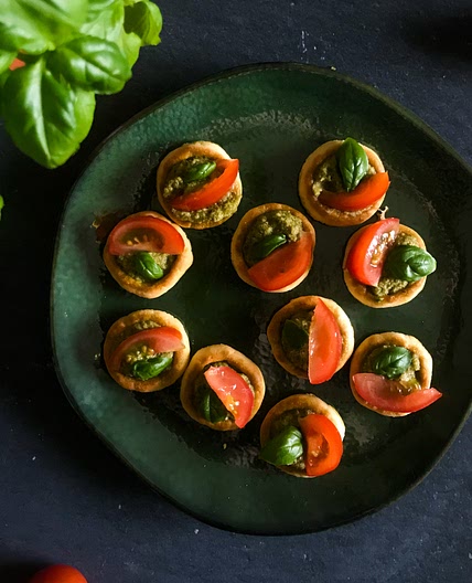 Crackers with pesto, cherry tomatoes & fresh basil
