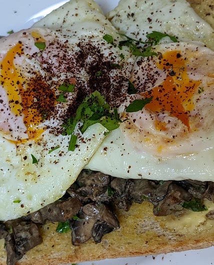 Creamy mushrooms, fried eggs on toast