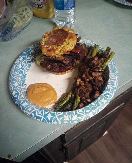 A Burger with a broccoli cheese bread