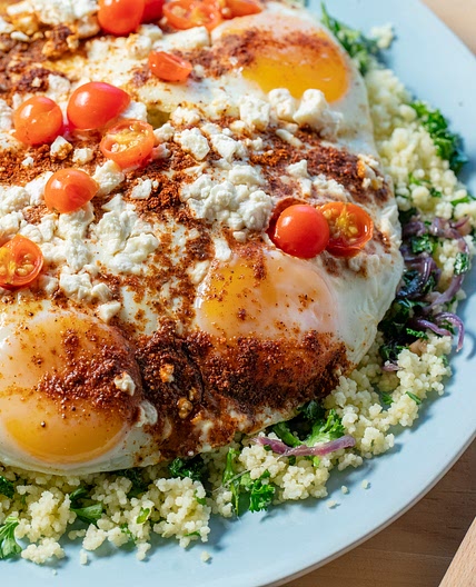 Œufs poêlés avec baharat, chou frisé et féta avec couscous citronné au persil