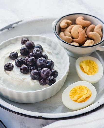 Breakfast bento with yogurt, egg, blueberries and cashews