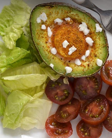 Huevos al horno sobre aguacate con queso de cabra.