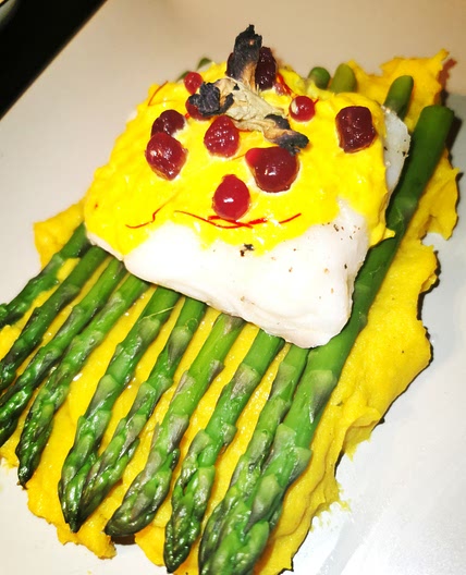 Asparagus with cod and saffron sauce with butterfly pea flower jellies laid on a bed of curry potato mash
