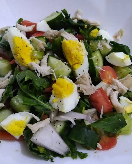 Greek salad with spinach, carrots and egg with chicken
