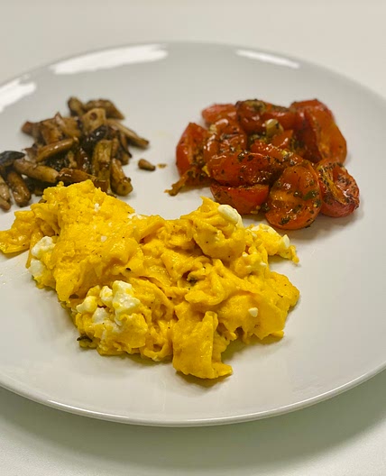 Scrambled eggs with goat feta, mushrooms and rosted tomato