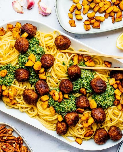 Spaghetti mit Rucola-Pesto, pflanzlichen Bällchen & knusprigen Pastinakenstückchen