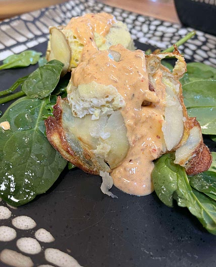 Egg, sausage, potato breakfast with chili-sour cream sauce