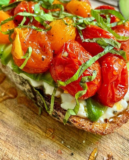 Happy Toast Tuesday ☺️☺️ ⠀ 1 slice sourdough 1 cup cherry tomatoes 2 tbsp olive oil 1/4 cup cottage cheese or ricotta 1/2 avocado, sliced 2-3 basil leaves, chopped Hot honey Salt and pepper 1. Preheat oven to 425°F. Place tomatoes in a ramekin, season with