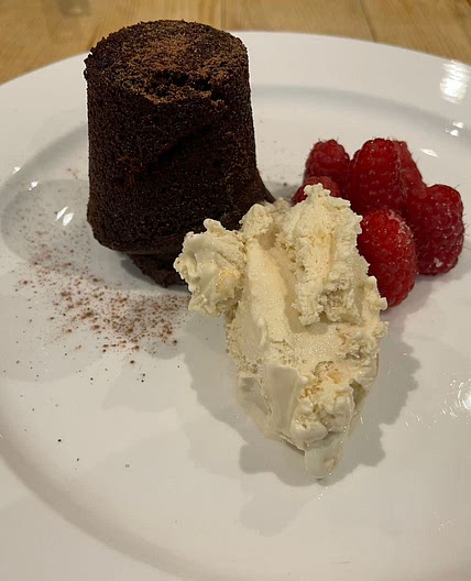 Chocolate fondant with fresh raspberries and vanilla ice cream/ fresh cream.