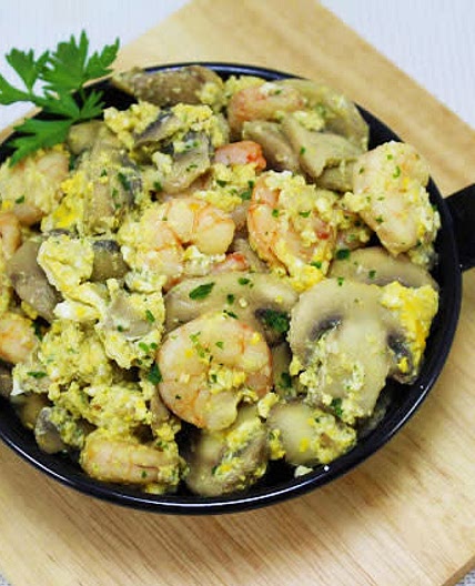 Huevos revueltos con verdura, champiñones y gambas