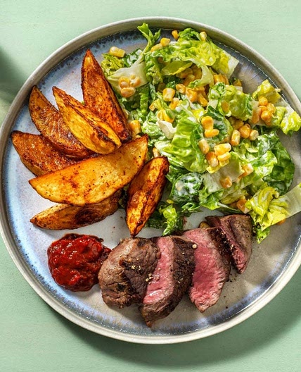 24 Rinderhüftsteak mit Kartoffelspalten, Pflaumenketchup und grünem Salat mit Mais