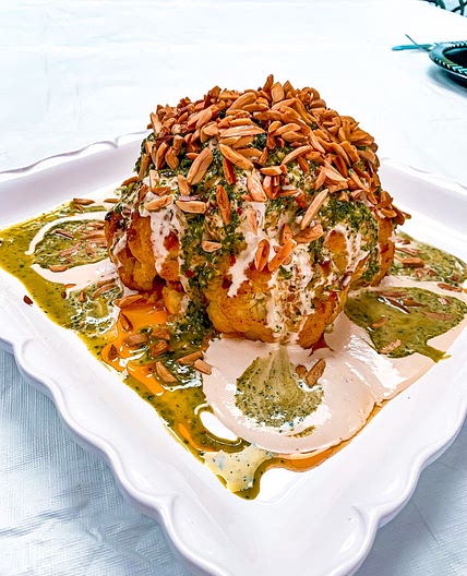 SPICY ROASTED WHOLE CAULIFLOWER WITH CILANTRO SAUCE, TAHINI SAUCE & CRUNCHY ALMONDS