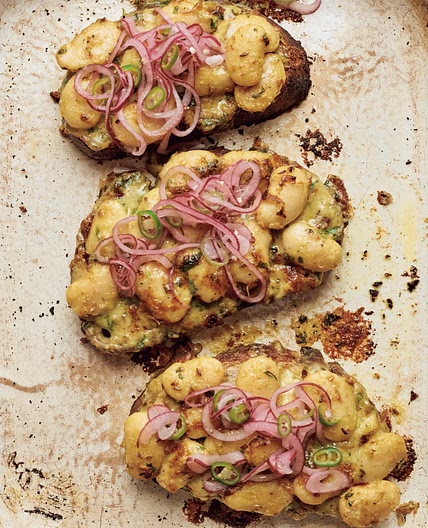 Cheesy curried butter beans on toast with pickled onion