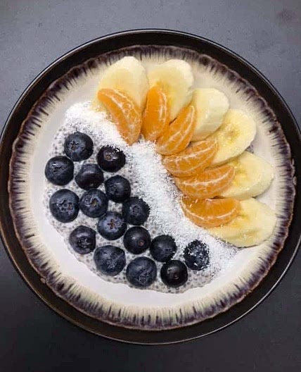 Chia seeds pudding with blueberries, banana, clementine and coconut flakes