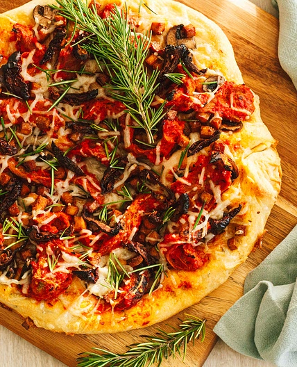 Roasted Red Pepper Vegan Chicken, Tofu Bacon, Mushroom, Sun Dried Tomato Pizza with Fresh Rosemary Leaves and a Herbed Crust