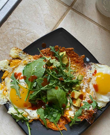 Fried cheese and eggs with avocado salad