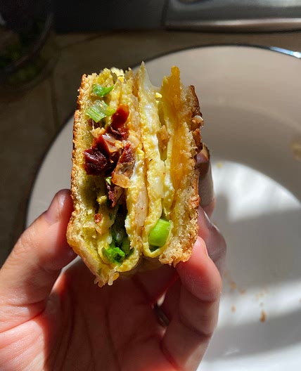  Breakfast sandwich with sundried tomatoes, spinach, and cheese.