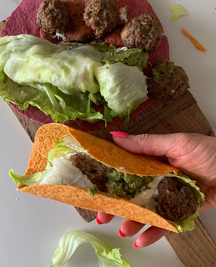 Greek meatballs with pea-pistachio pesto in colorful wraps