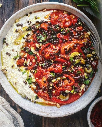 Hummus bowl with harissa pepper and olive gremolata