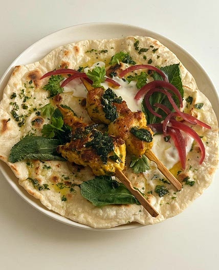garlic herb flatbread with turmeric chicken skewers with mint leaves