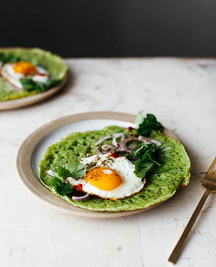 green lachuch with a fried egg, herbs, and cheese