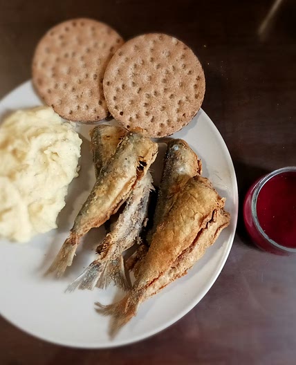 Fried herrings with smashed potatoes and sauce of red fruits