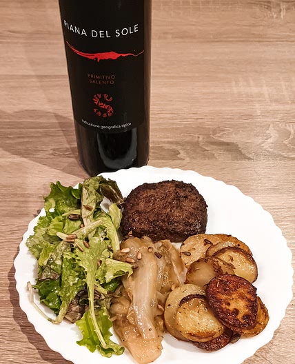 Steak haché au chicon caramélisé avec tranches de pommes de terre et salade fraîche