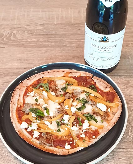 Pizza rouge sur pain plat garnie de viande hachée, mozzarella