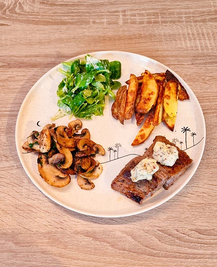 Steak frites et beurre aux herbes champignons frits et salade de blé