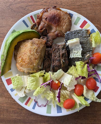 Pork chop, chicken thigh, salmon, and churrasco with avocado, lettuce, baby tomatoes, and purple onion