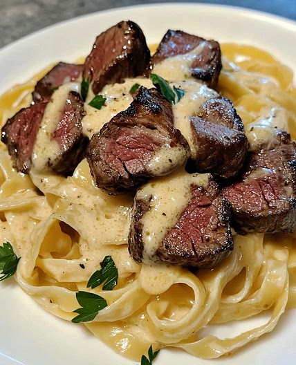 Steak bites in fettuccine garlic butter sauce
