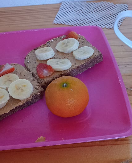 Peanut butter toast with banana and strawberries