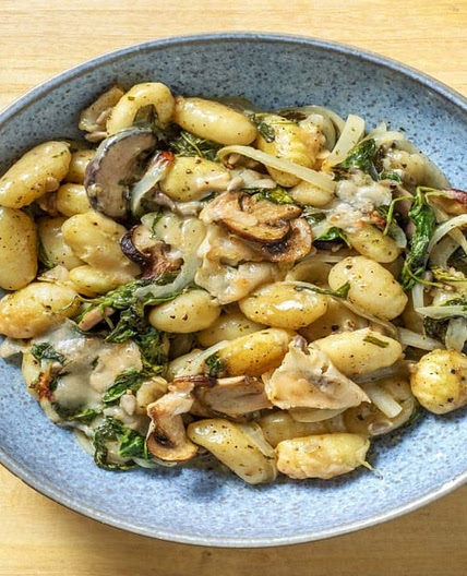 Gnocchi-Spinat-Auflauf mit Champignons in Basilikumcremesoße, dazu Sonnenblumenkerne
