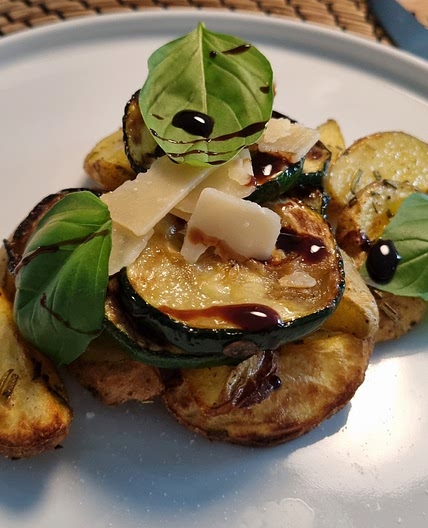 Zucchini-Pfanne mit Pinienkernen & Parmesan auf einem Rosmarienkartoffelbett