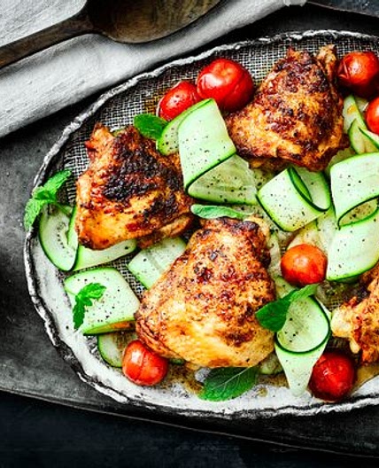 Paprika chicken thighs with cherry tomatoes, courgette ribbons and mint