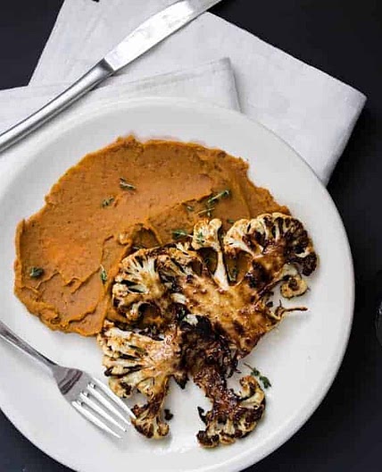 Roasted cauliflower steaks on spicy sweet potato puree