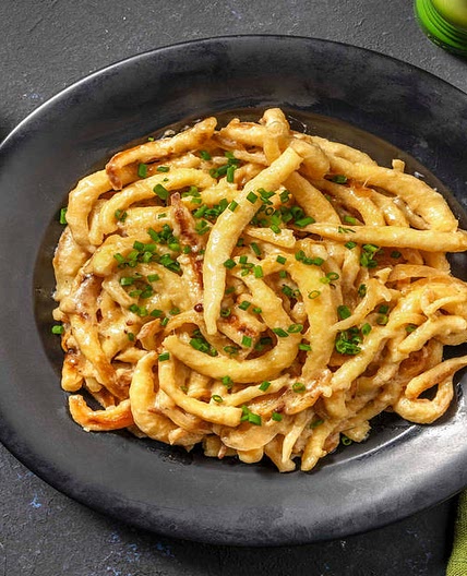 Cremige Spätzlepfanne mit Schmelzzwiebeln und Gurken-Radieschen-Salat