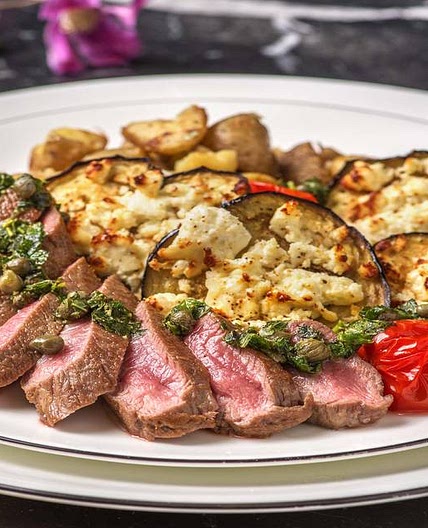 Mediterranean Lamb Loin with Garlicky Crushed Potatoes with Feta Roasted Aubergine, Roasted Tomatoes and Salsa Verde