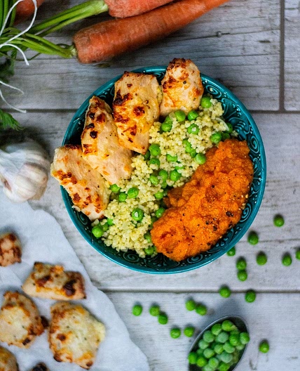 Roasted chicken pieces in yogurt marinade with millet porridge, peas, and carrot purée