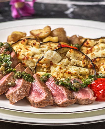 Mediterranean Lamb Loin with Garlicky Crushed Potatoes with Feta Roasted Aubergine, Roasted Tomatoes and Salsa Verde