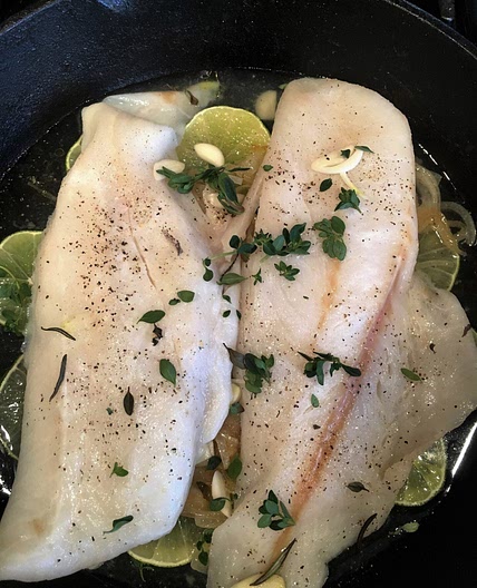 Dover sole with caramelized onions in a skillet